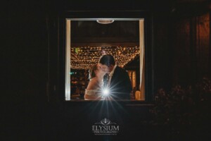 A photograph of a couple kissing taken through a window at Bendooley Estate Book Barn