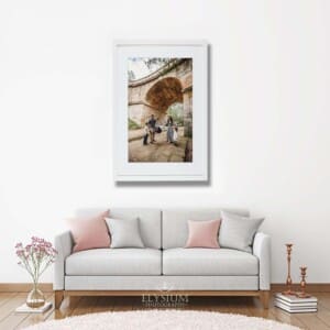 A white framed print of a family portrait hangs above a lounge