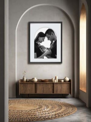 An arched framed print of a family portrait hangs in a hallway