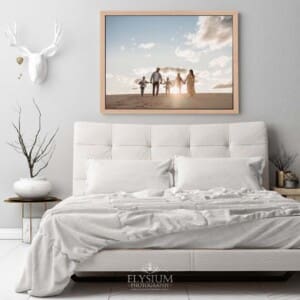 A framed canvas print of a family portrait hangs above a bed