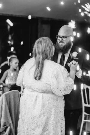 A husband and wife share their first dance as sparklers light up at the side of the dancefloor at Ottimo House