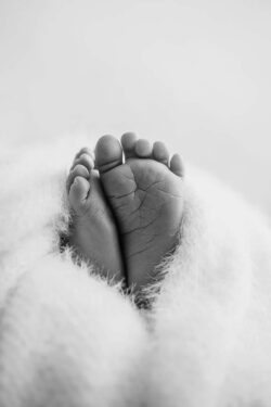A black and white photo showing the little lines on a tiny newborn baby's foot