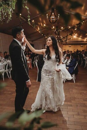 A groom twirls his bride during their first dance at their Burnham Grove wedding reception