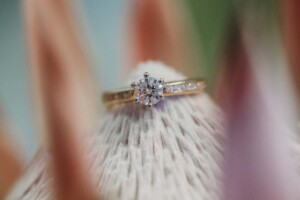 A brides engagement ring sits on the peak of a king protea in her wedding bouquet