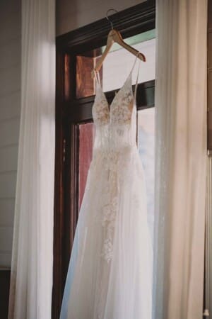 A brides wedding dress hangs in a doorway at Burnham Grove before her wedding ceremony