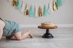 A baby crawls away from his birthday cake after smashing it