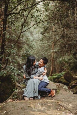 A mother hugs her boy as they sit together on a huge rock at Lennox Bridge