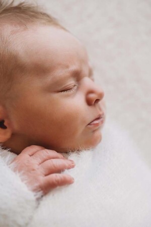 Profile of a sleeping newborn baby showing tiny details on their face