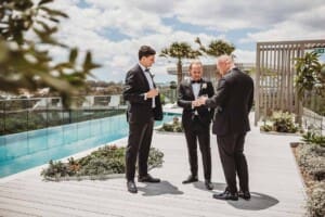 A groom shares a drink with his groomsmen as they get ready for the wedding
