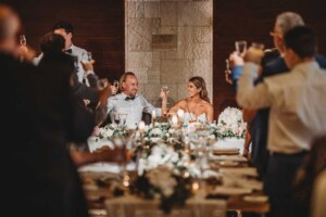 A bride and groom share a toast with their guests during the wedding reception