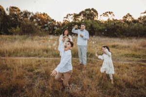 Children giggling as they run around their parents chasing bubbles, a fun‑filled highlight from their South West Sydney outdoor session