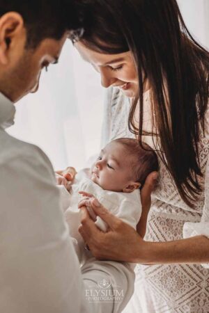 Parents admiring their newborn during a gentle studio session with an Ingleburn photographer