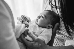Close view of a newborn resting peacefully in her parent’s arms during a studio session in Ingleburn