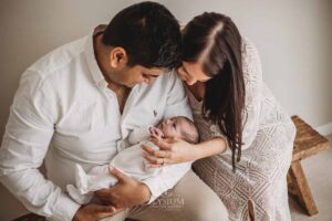 Parents cuddling their newborn in soft studio light, photographed by an Ingleburn newborn photographer