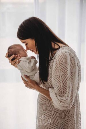 Mother kissing her newborn’s nose in soft natural light at the Ingleburn studio