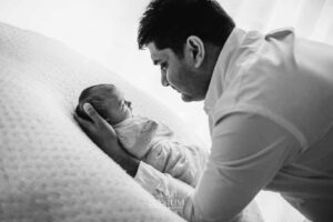 Father gazing at his newborn during a tender moment in the Ingleburn natural‑light studio