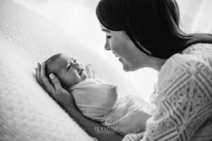 Baby resting on a textured blanket in her mother's arms, photographed by a newborn photographer