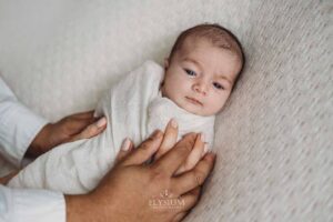 Newborn laying in her parent's hands during a quiet moment in the Ingleburn studio session